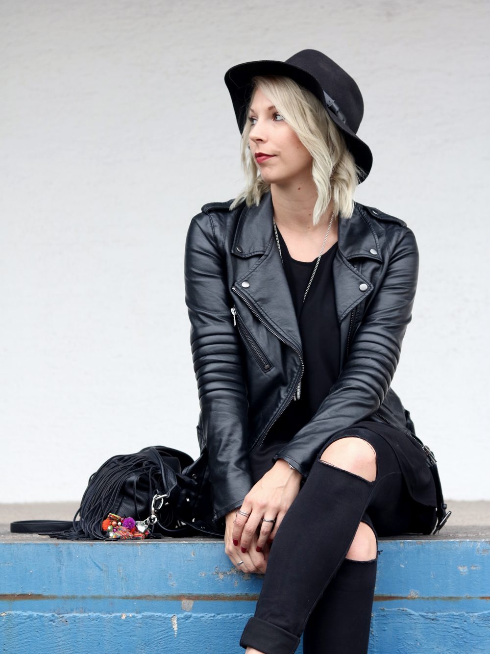 Fashionblogger Outfit all in black Jeans Lederjacke Hut Fransentasche Bikerboots (13)